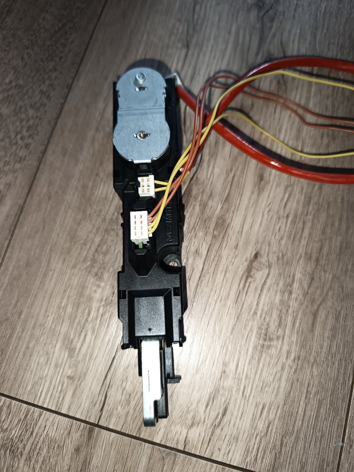 s-l1600-1003.jpg Electrical module with a small DC motor in a black plastic housing, connected to yellow and brown wire harnesses on a wooden floor description.