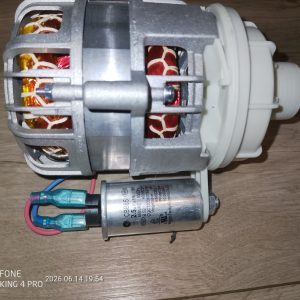 DC electric motor assembly with a metal housing and white plastic coupling, wires connected at the bottom, laid on a wooden surface.