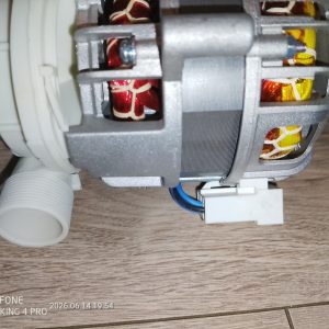Internal view of an electric motor with copper windings and a white plastic hose connector on the left; blue and black wires exit a white connector at the bottom.