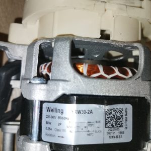 Close-up of a Welling YKW30-2A electric motor showing copper windings and internal wiring inside the housing.