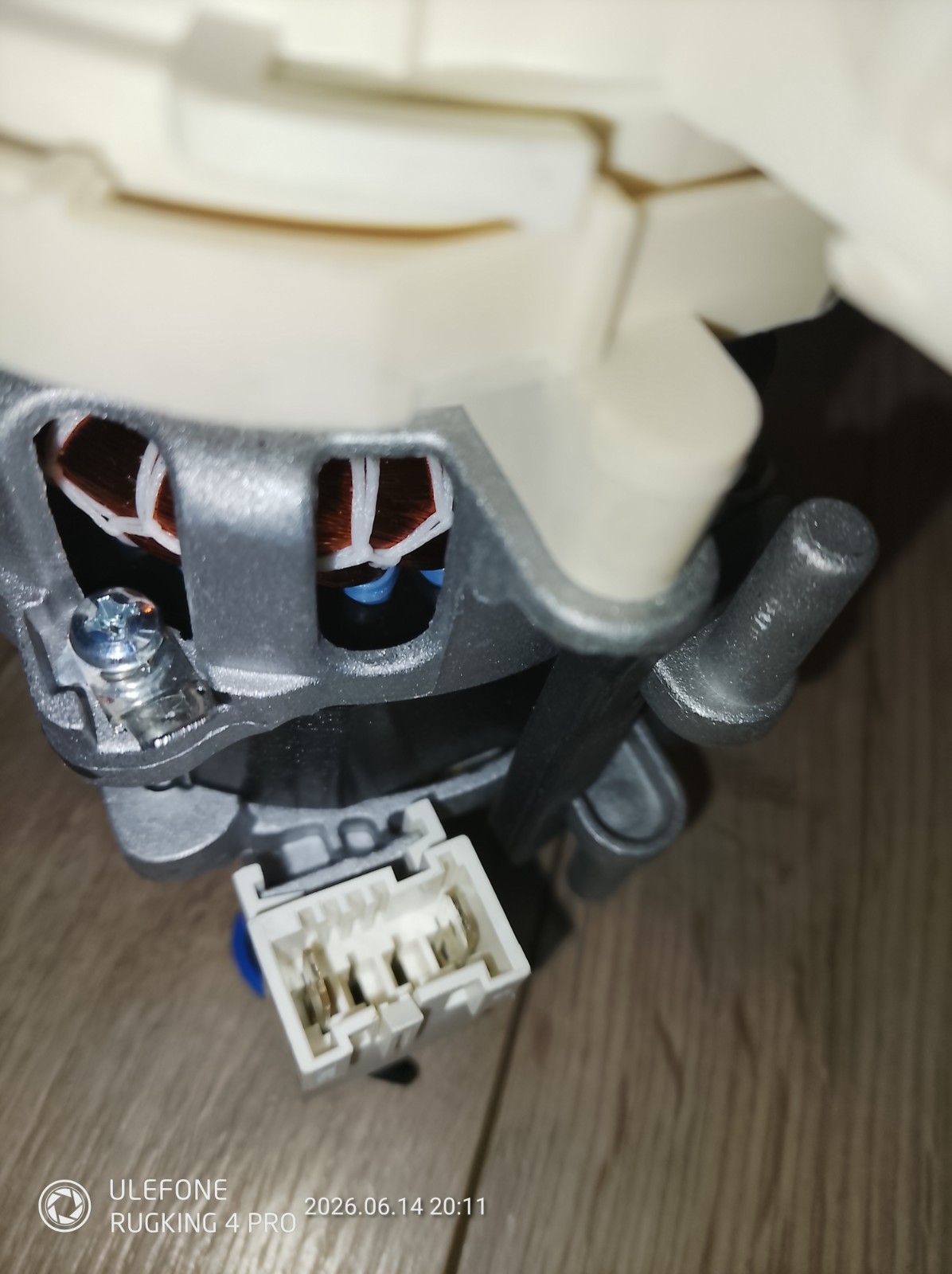 s-l1600-1158.jpg Close-up of a small motor showing copper windings, a white connector, and a gray mounting bracket.