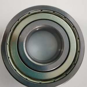 Close-up of a metal ball bearing race with multiple grooves and an inner bore.