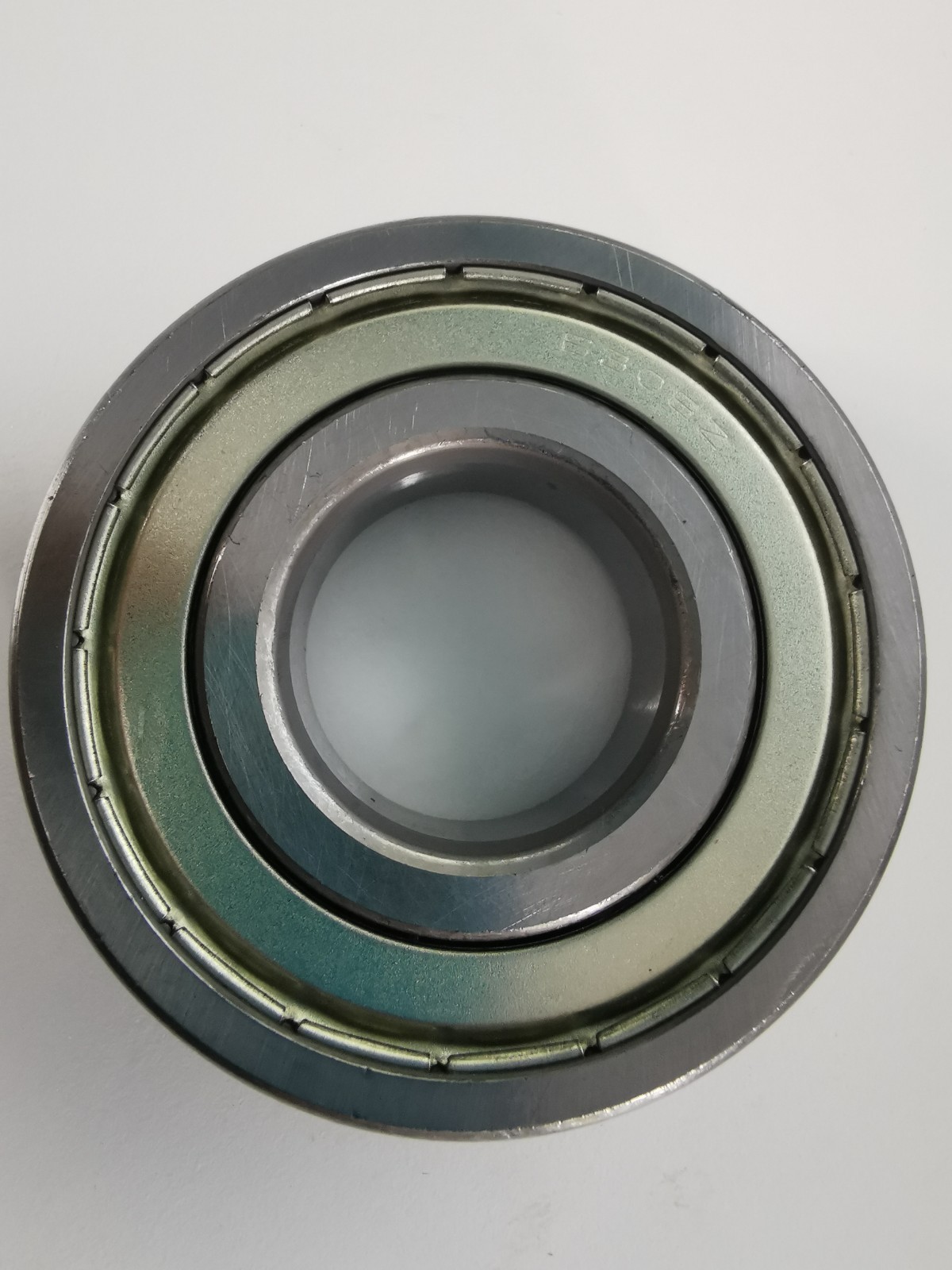 s-l1600-1168.jpg Close-up of a metal ball bearing race with multiple grooves and an inner bore.