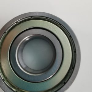 Close-up of a metal bearing showing inner and outer races, captured from the edge to reveal the circular components