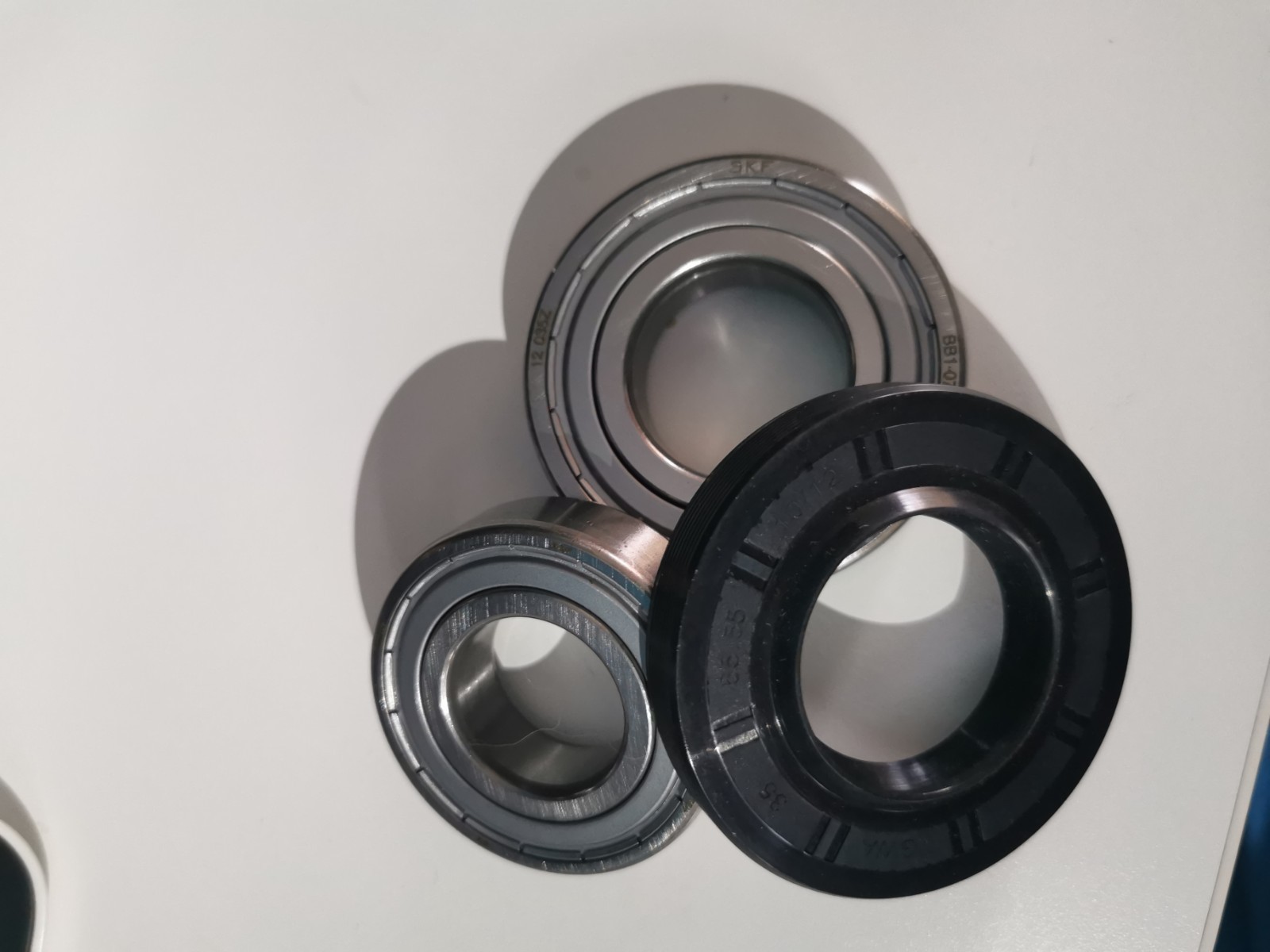 s-l1600-1174.jpg Close-up of metal bearing components: two inner race rings and a black rubber seal on a white surface