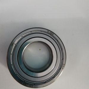 Close-up of a metal circular mechanical part with concentric rings and a glassy center image area.