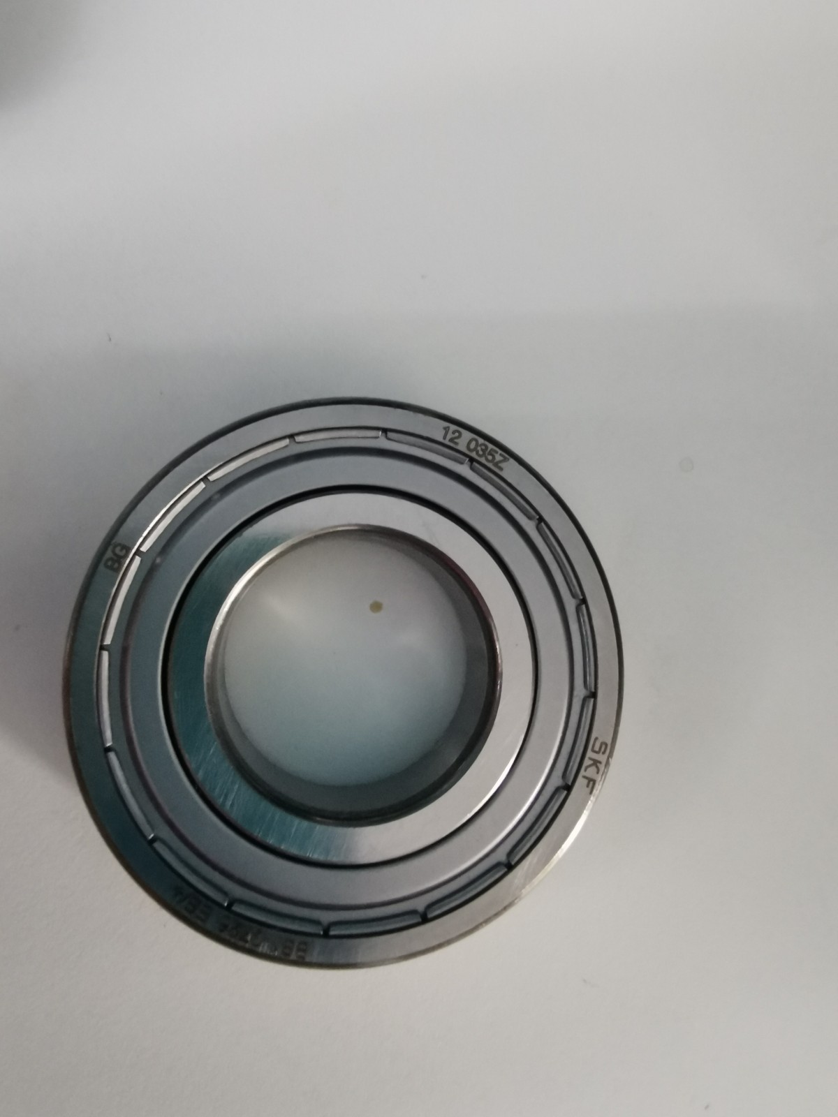 s-l1600-1177.jpg Close-up of a metal circular mechanical part with concentric rings and a glassy center image area.