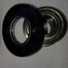 Close-up of two circular camera lens adapters stacked together on a textured white background.