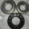 Three metal bearings laid on a plastic bag, two open-center ball bearings with stamped markings and a black-sealed bearing nearby