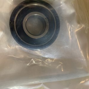 Close-up of a metal sink drain with a circular stopper and a ring, showing engraved text WK04-2022 on the rim within a reflective stainless surface.