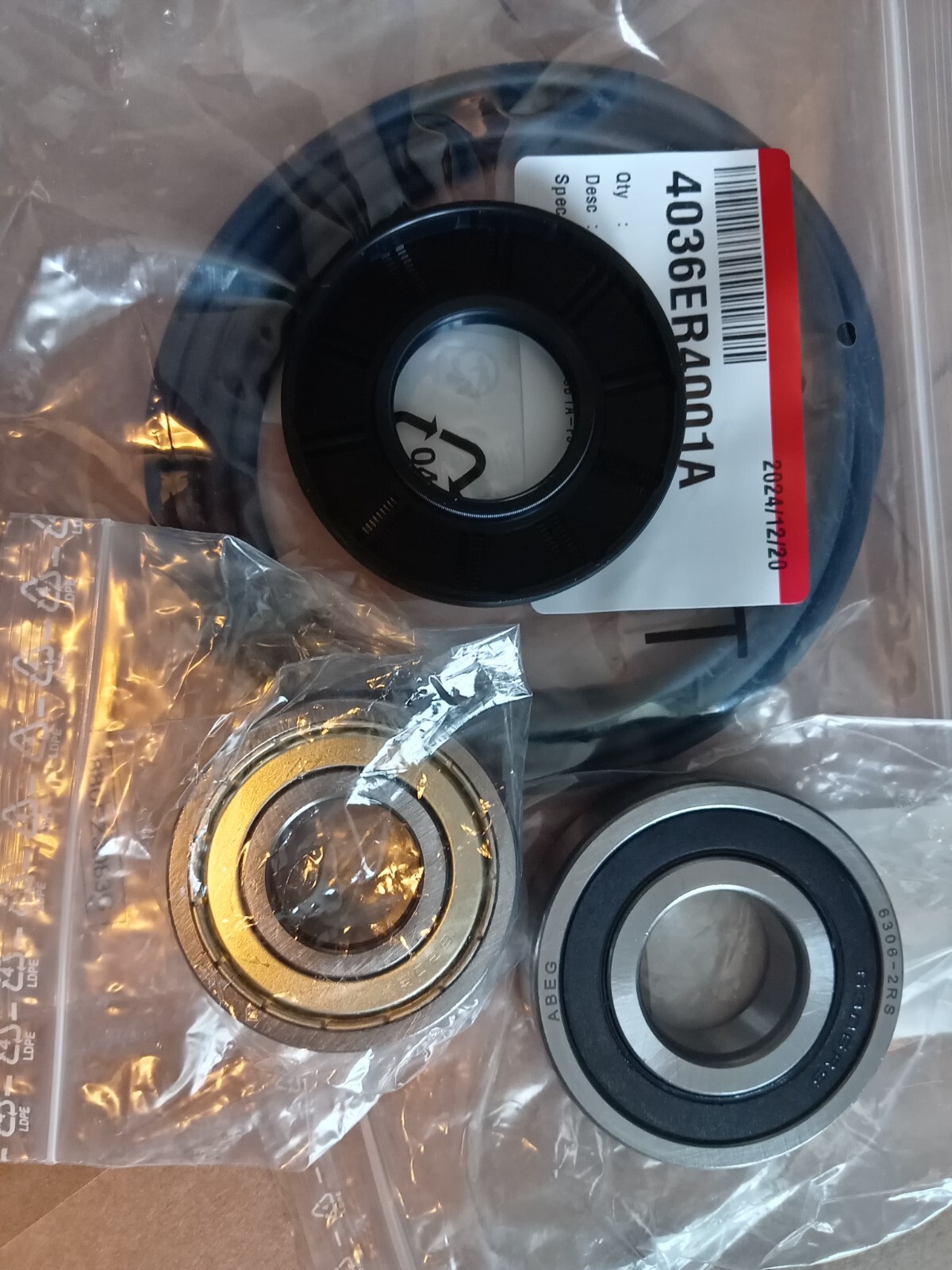 s-l1600-148.jpg Close-up of bearing components and a black plastic hub resting on clear packaging with a white label visible in the background.