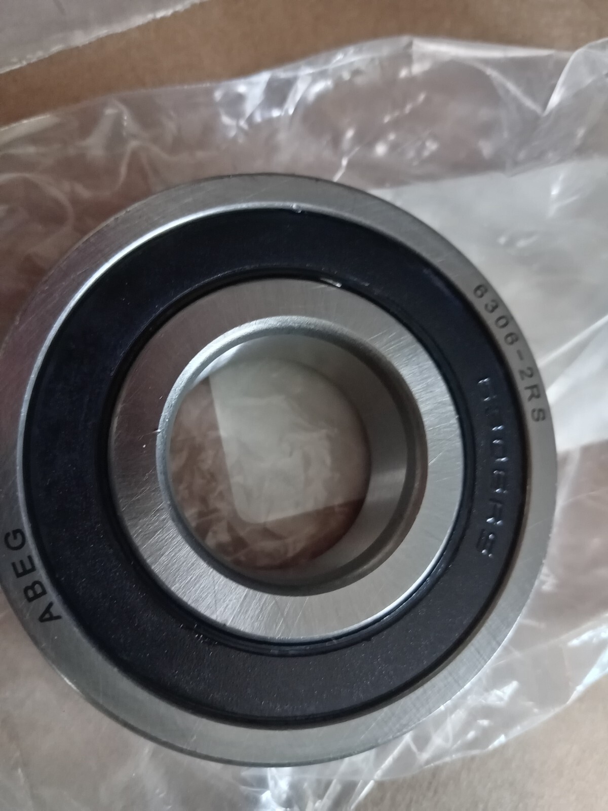 s-l1600-149.jpg Close-up of a metal ball bearing with inner and outer races, resting on clear plastic wrap.