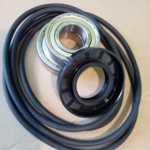 Coiled drive belt with a metal bearing and a black pulley resting on top, showing a circular metal race and inner hole.