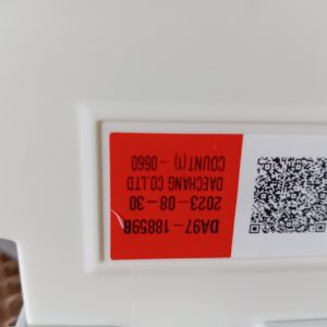 Label on white appliance: red panel with upside-down numbers and a QR code next to a barcode.
