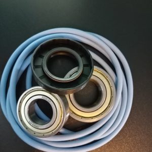Blue coiled hose resting under three metal ball bearings on a dark surface.