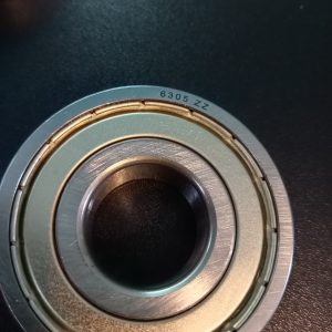 Close-up of a metal ball bearing stamped with 6305 ZZ on the outer ring.