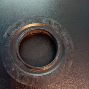 Close-up of a camera lens mount: black circular ring with small screws and engraved markings around the edge.