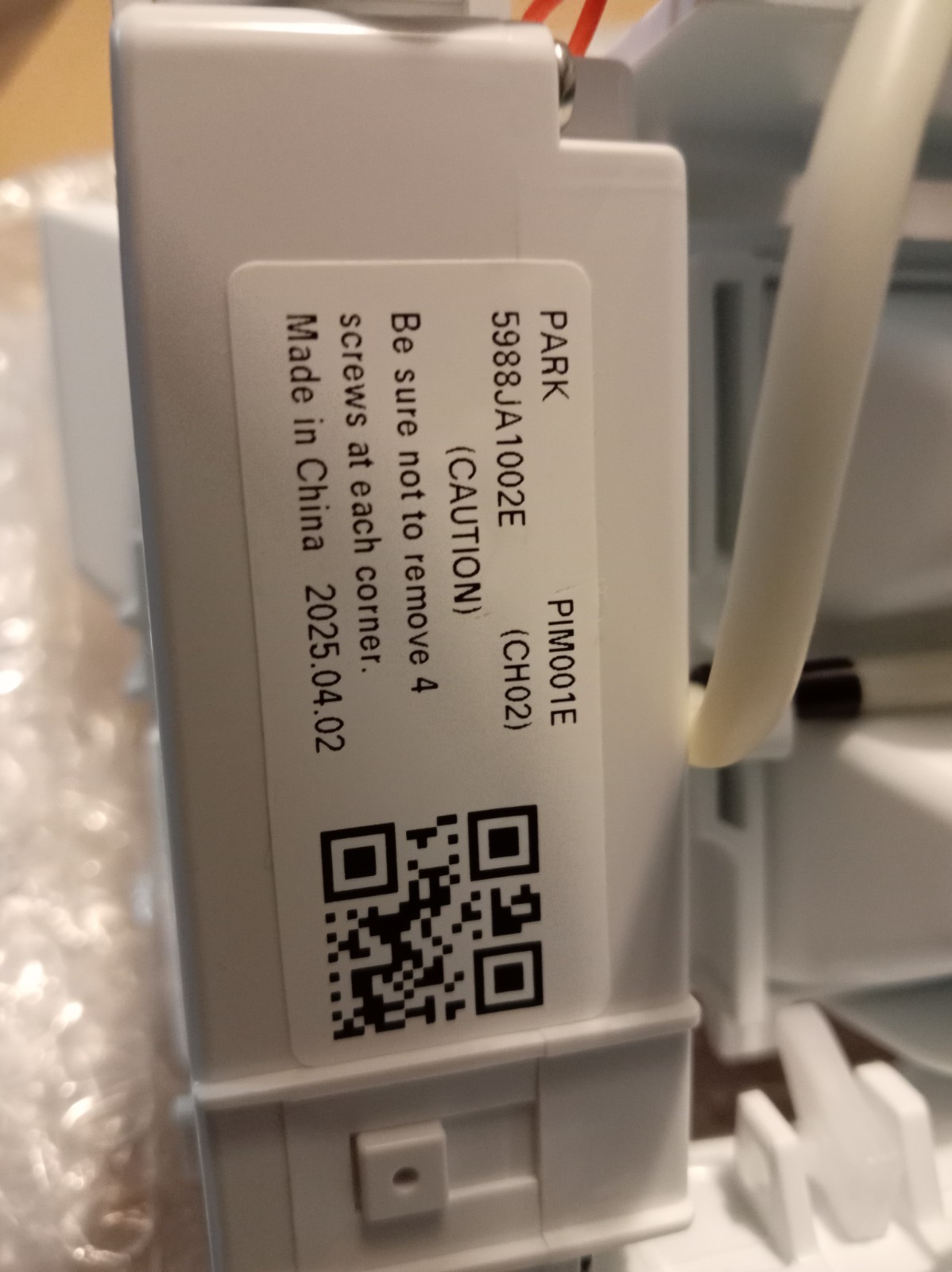s-l1600-244.jpg Close-up of a gray plastic device with a white label showing a product code, caution text, origin, and a QR code.