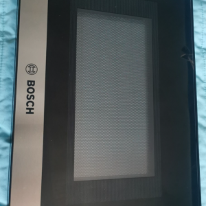 Bosch-branded kitchen appliance door with a brushed metal strip on the left and a large glass viewing window