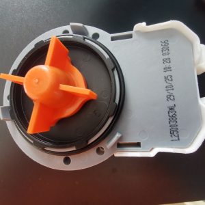 Close-up of an orange plastic rotary knob inside a gray circular housing, likely a control switch. The device shows a black inner ring and molded plastic housing with stamped numbers.