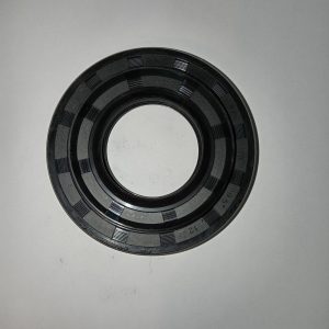 Black circular mechanical seal or gasket with inner/outer rings and segmented textured grooves, viewed from above on a light surface.