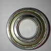 Close-up of a circular metal bearing with inner and outer races, a mechanical component for reducing friction in machinery.