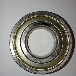 Close-up of a circular metal bearing with inner and outer races, a mechanical component for reducing friction in machinery.
