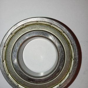 Close-up of a metal ball bearing race with inner and outer rings, stamped ABEC on the outer edge on a white background