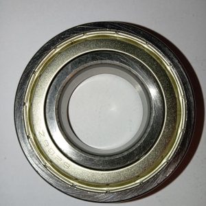 Close-up of a metal bearing with inner and outer rings and a light-colored seal, viewed from above for mechanical context.