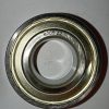 Close-up of a metal ball bearing with inner and outer rings, stamped with '6205ZZ'.
