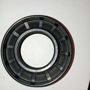 Close-up of a metal bearing: circular outer and inner races with evenly spaced segmented sections for rolling elements, used to allow smooth rotation.
