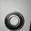 Metal ball bearing viewed from above, outer race stamped 5205RS on a white background.