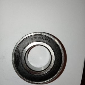 Metal ball bearing viewed from above, outer race stamped 5205RS on a white background.