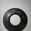 Circular black gasket with inner bore resting on a white surface, showing etched numbers on the edge (machinery seal).**