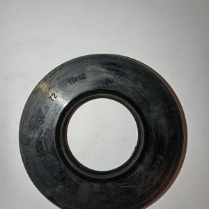 Circular black gasket with inner bore resting on a white surface, showing etched numbers on the edge (machinery seal).**
