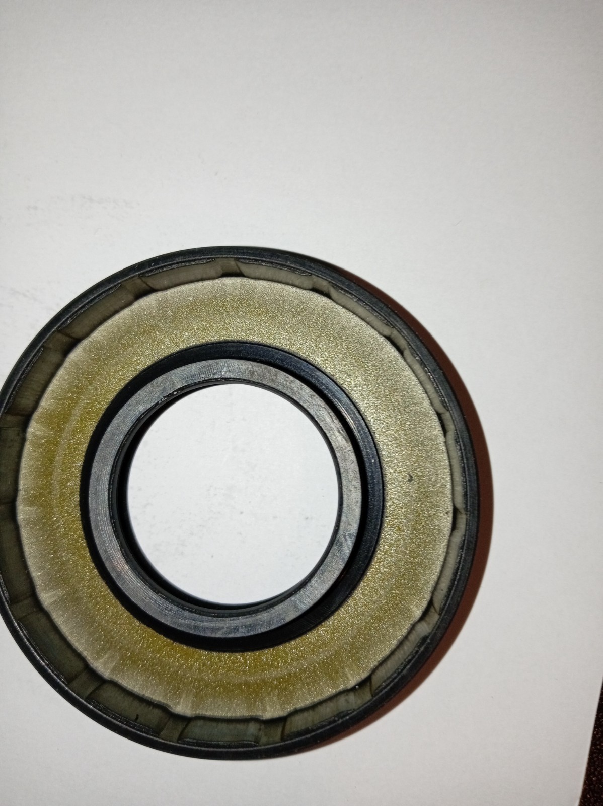 s-l1600-283.jpg Close-up of a metal bearing showing concentric inner and outer races with a dark bore in the center.