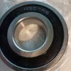 Close-up of a metal ball bearing with 6307RS stamped on the outer ring, resting on plastic wrap.