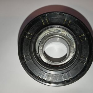 Close-up of a metal bearing with grease, showing inner race and outer ring.