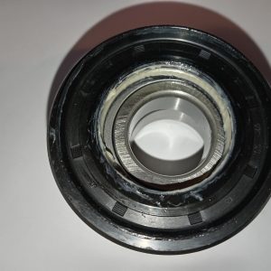 Close-up of a grease-filled bearing inside a black seal, with a silver inner race exposed.
