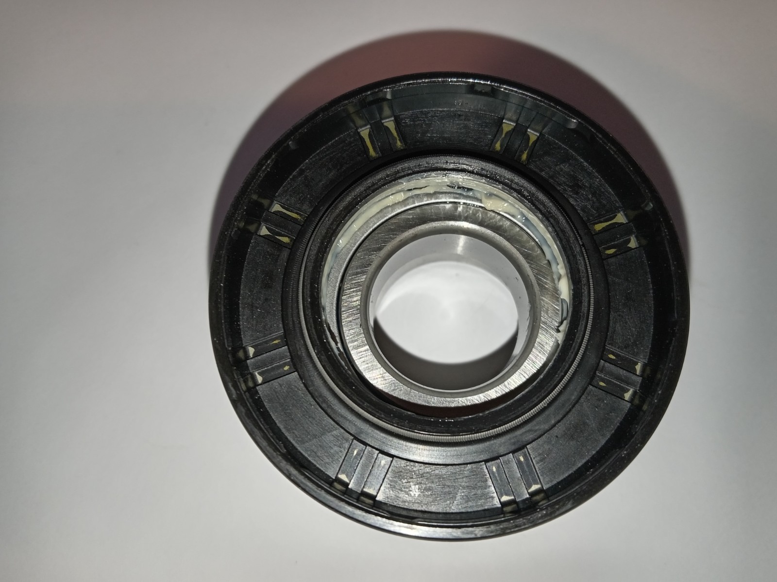 s-l1600-323.jpg Close-up of a metal bearing with grease around the inner race and grooves visible on the outer ring