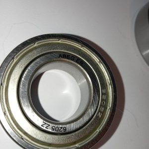 Close-up of a metal ball bearing with inner and outer races, showing ABEC markings on the ring