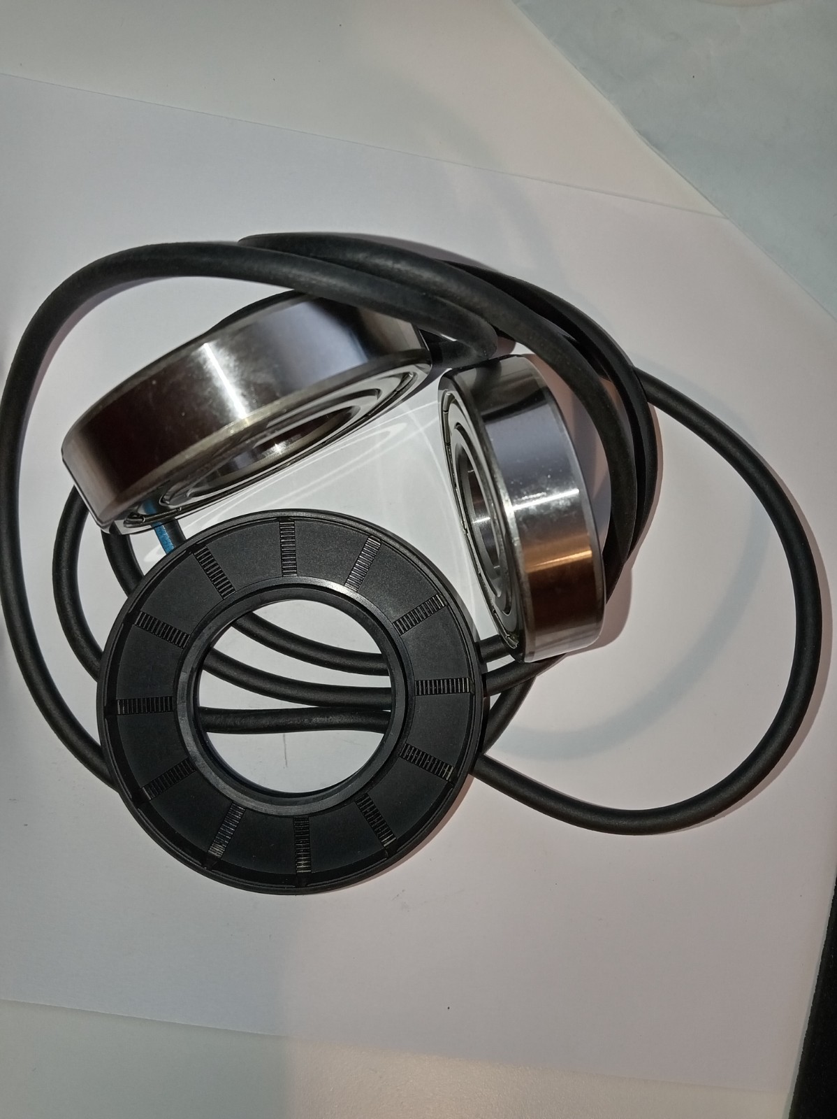 s-l1600-330.jpg Black over-ear headphones with metal silver rims resting on a white surface, cable looping around them.