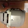 Industrial motor with gear housing placed on a brown cardboard box; a circular mounting ring is visible on the left side.