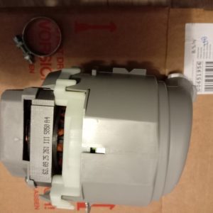Industrial motor with gear housing placed on a brown cardboard box; a circular mounting ring is visible on the left side.