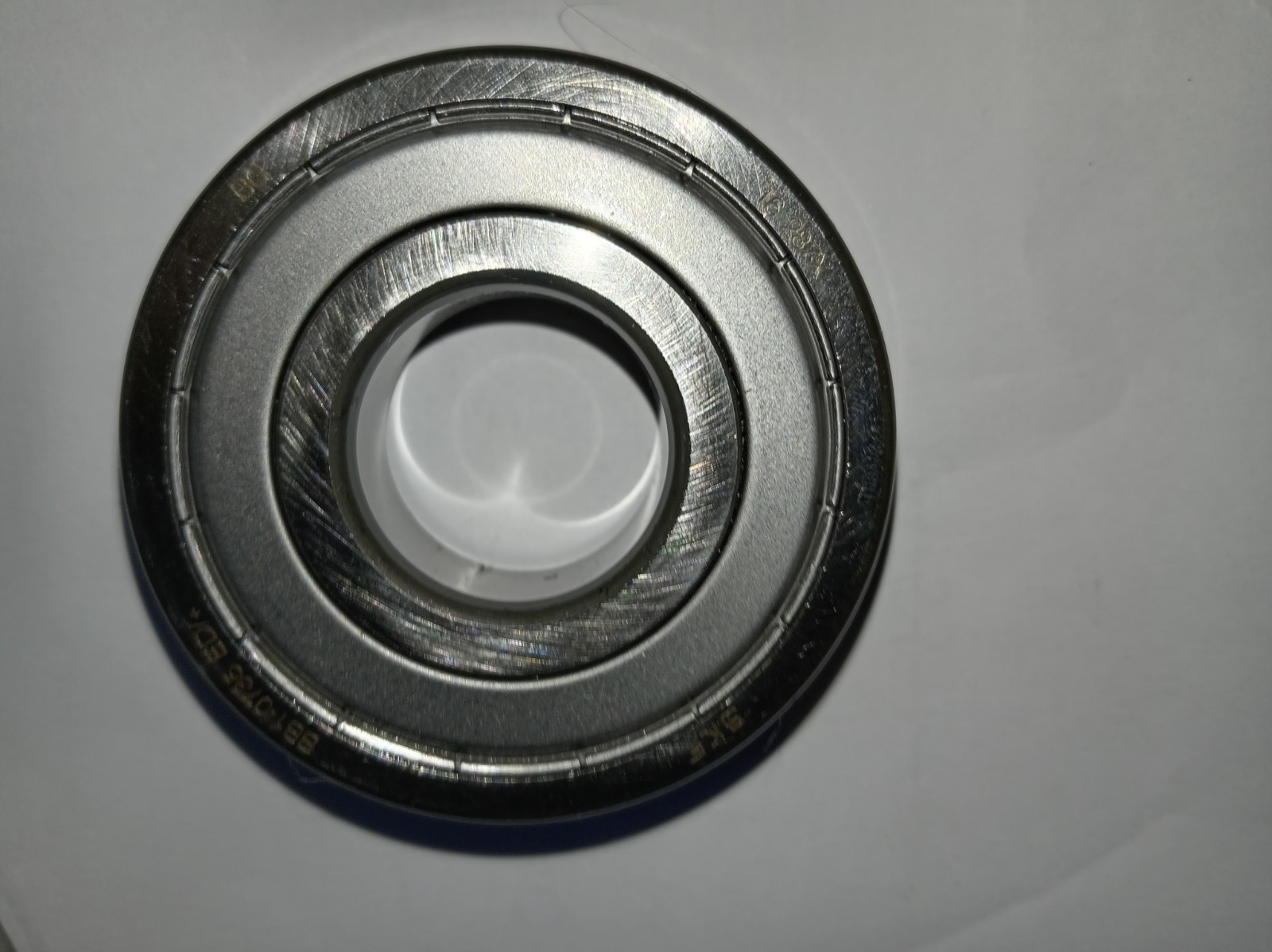 s-l1600-345.jpg Close-up of a metallic ball bearing with concentric rings on a light surface?