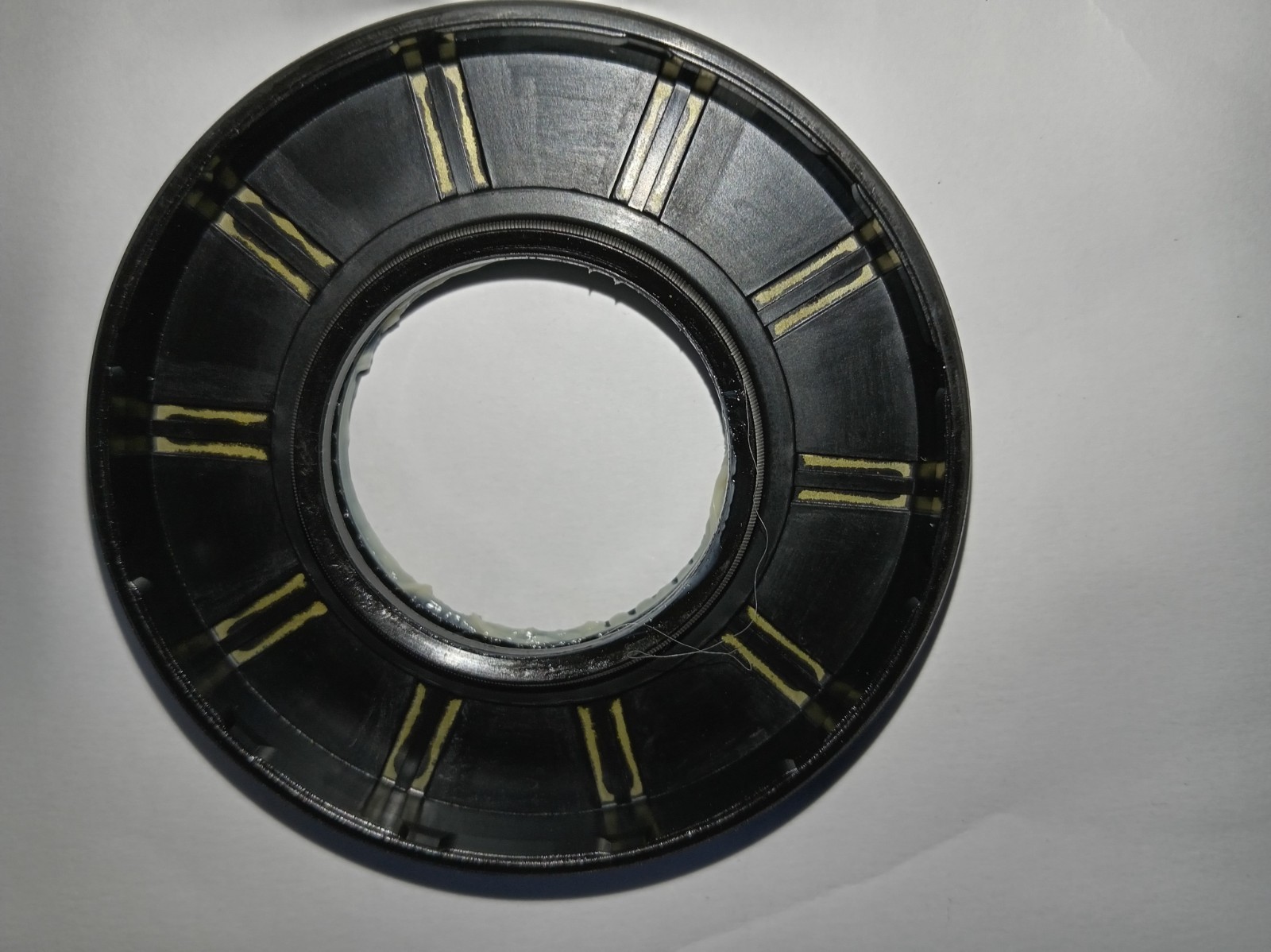 s-l1600-346.jpg Close-up of a black circular bearing or seal with an inner hole and yellow tape markings around the outer edge
