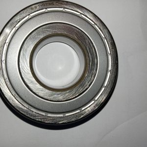 Close-up of a silver metal bearing or hub with concentric rings and grooved outer race, viewed from above
