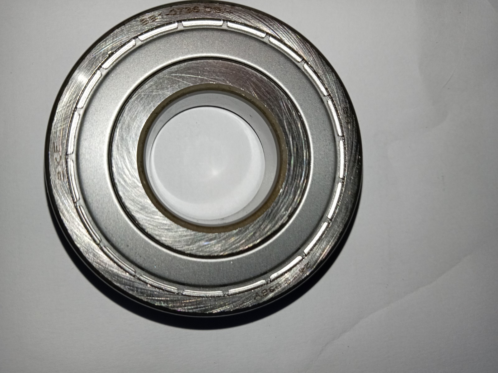 s-l1600-347.jpg Close-up of a silver metal bearing or hub with concentric rings and grooved outer race, viewed from above