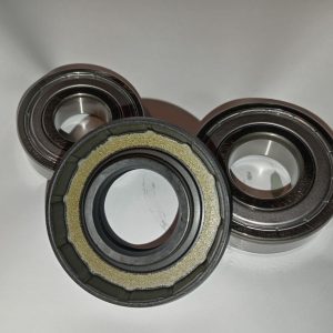 Three metal ball bearing assemblies placed on a white surface, showing inner races and seals.