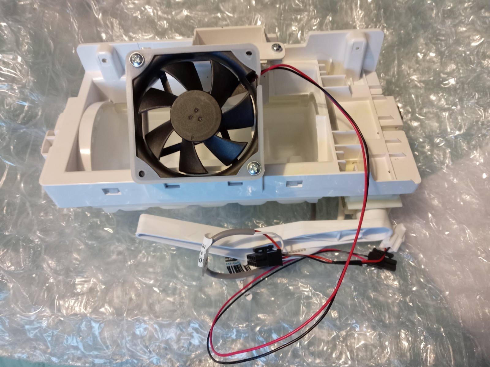 s-l1600-360.jpg White plastic electronic housing with a mounted black cooling fan and red/black wiring harness exposed
